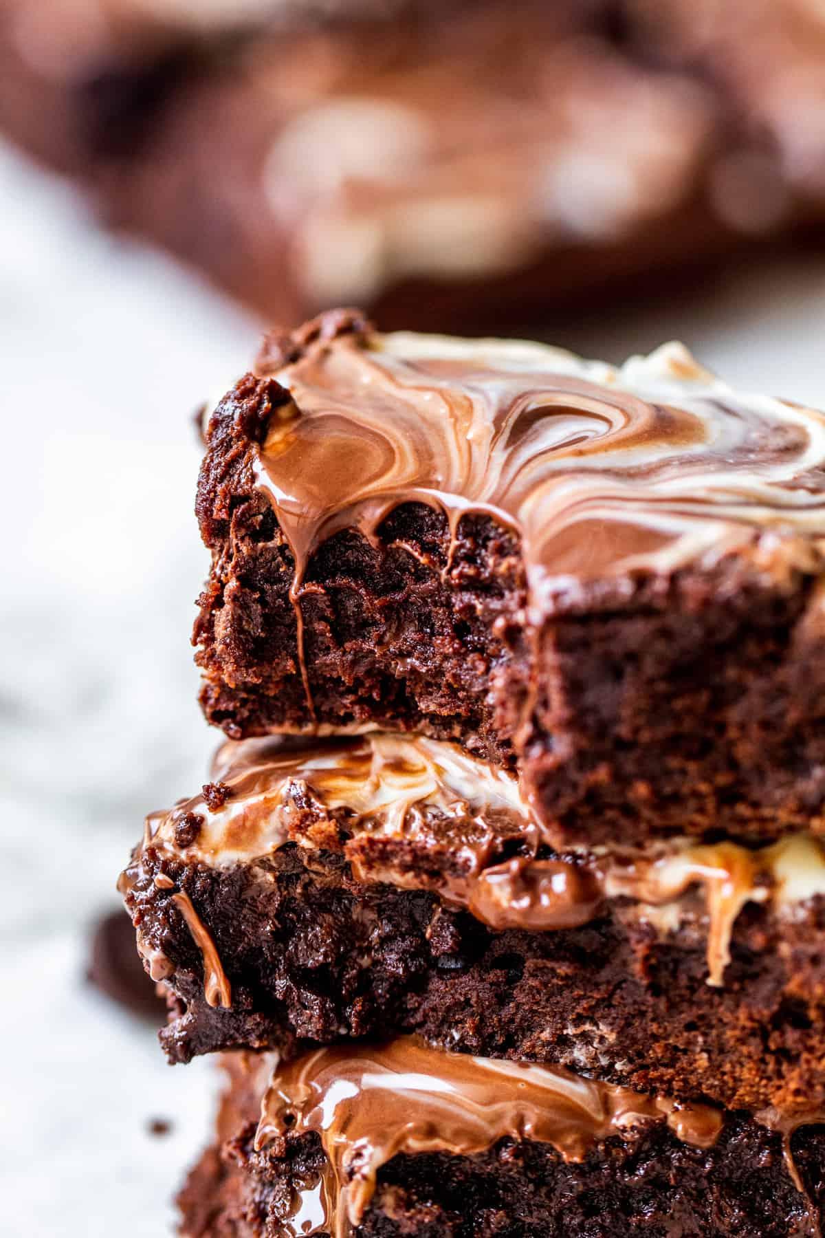 Stack of brownies with bite out of top one.